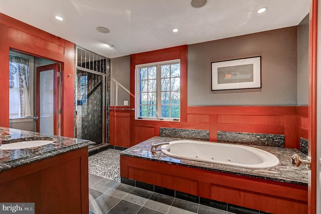 bathroom featuring a stall shower, a tub with jets, vanity, a wainscoted wall, and recessed lighting