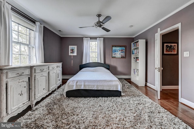 bedroom featuring crown molding, baseboards, a baseboard heating unit, and dark wood-style flooring