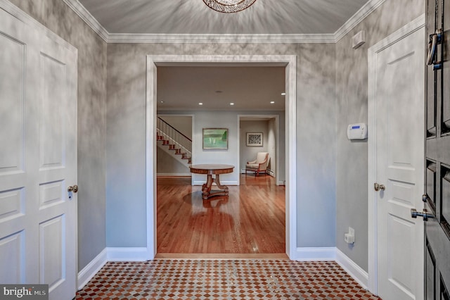 entrance foyer with baseboards, ornamental molding, and stairway