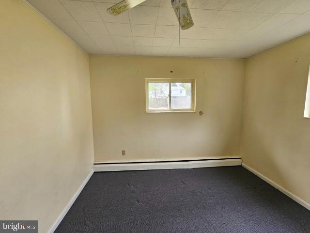 carpeted spare room with baseboards and baseboard heating
