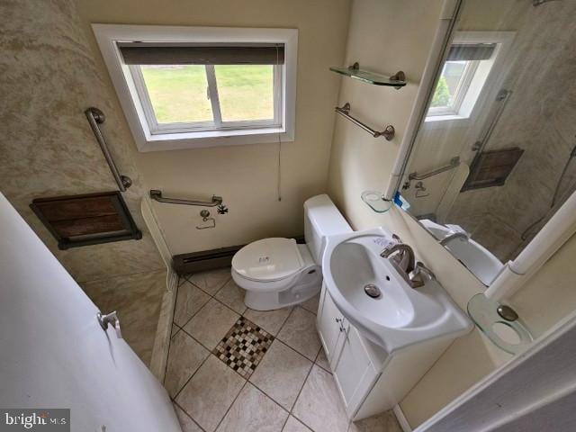 bathroom with toilet, plenty of natural light, tile patterned flooring, and vanity