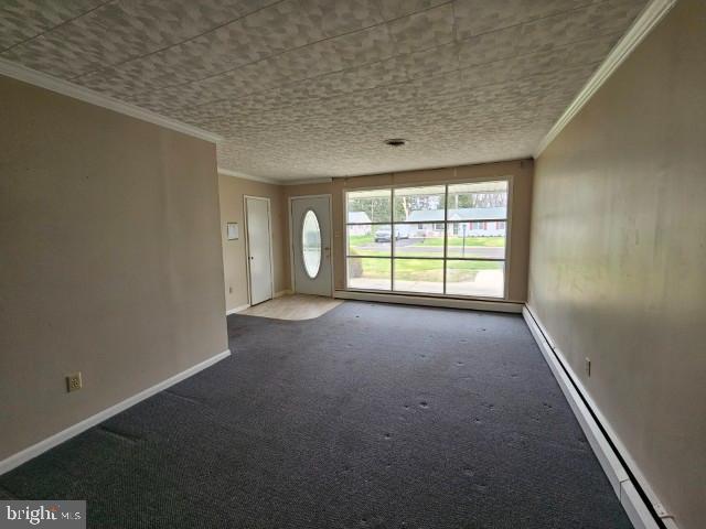 interior space featuring carpet flooring, baseboards, a baseboard heating unit, and ornamental molding