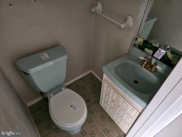 bathroom with vanity, baseboards, and toilet