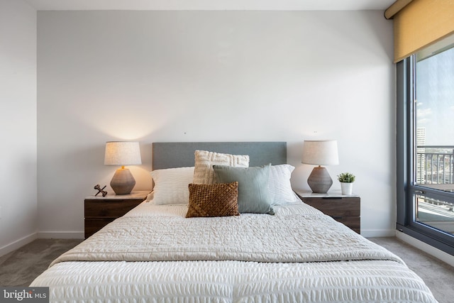 bedroom with baseboards, multiple windows, and carpet flooring