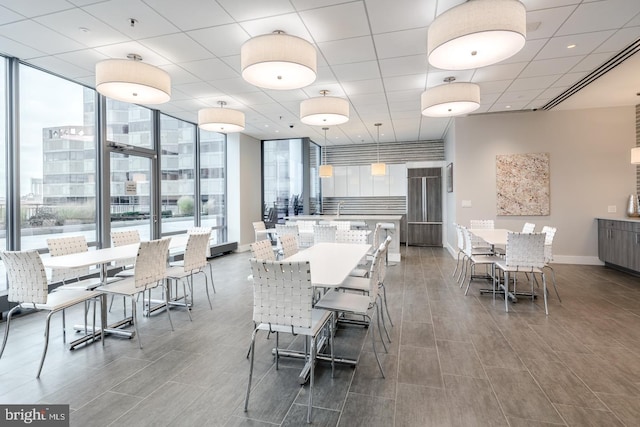 dining space with baseboards, expansive windows, and wood finished floors