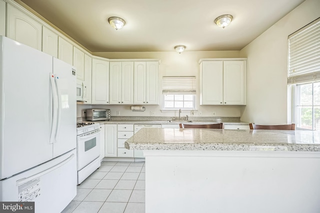 kitchen with a sink, white appliances, a toaster, white cabinetry, and light tile patterned floors