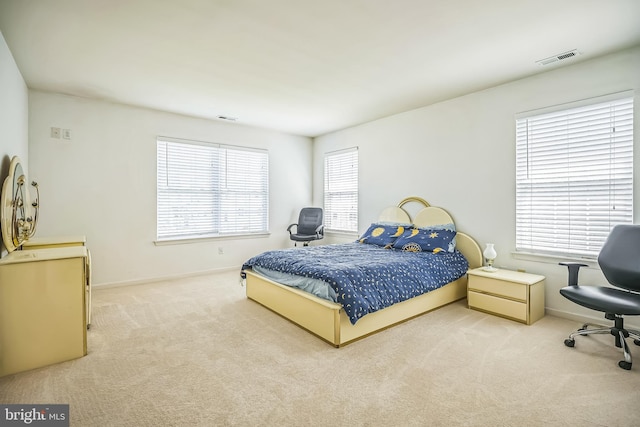 carpeted bedroom with visible vents and baseboards