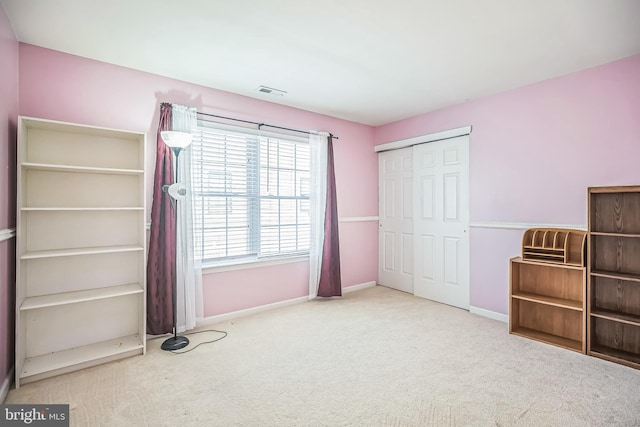 unfurnished bedroom with baseboards, carpet flooring, a closet, and visible vents