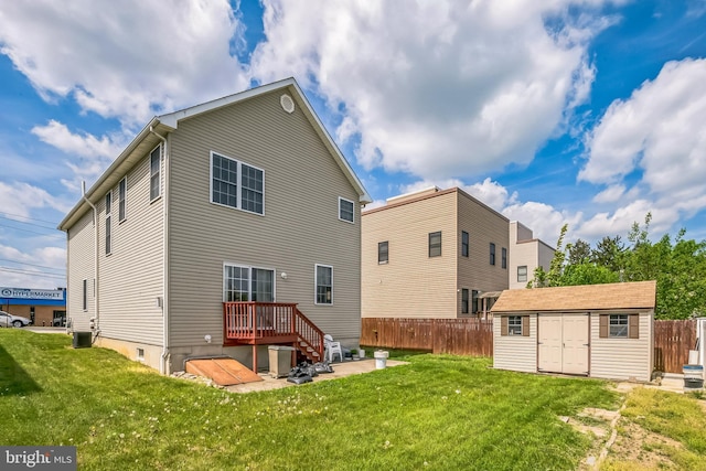 rear view of house featuring a lawn, central air condition unit, and fence