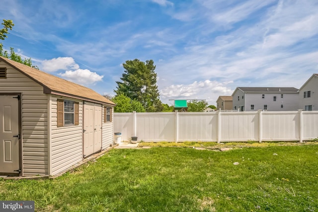 view of yard featuring a storage unit, fence, and an outbuilding