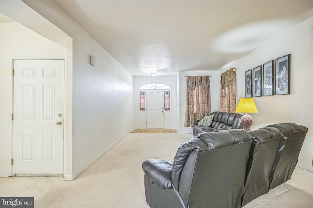 living area featuring light carpet and baseboards