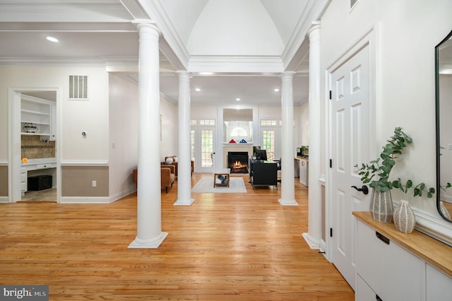 foyer entrance featuring crown molding, ornate columns, visible vents, and light wood-type flooring