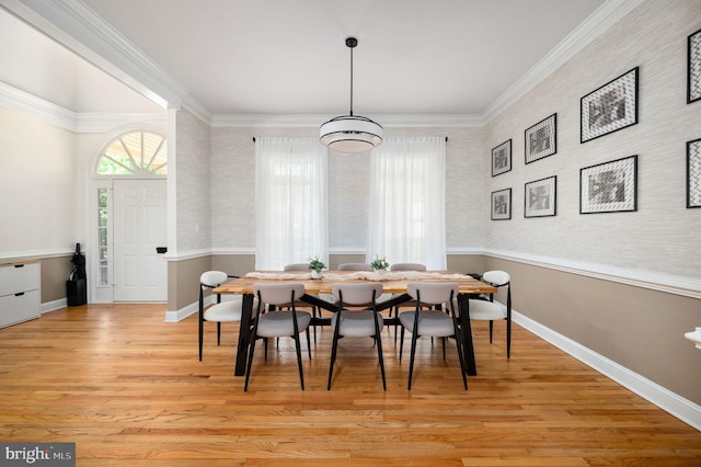 dining room with light wood-style floors, ornamental molding, and baseboards