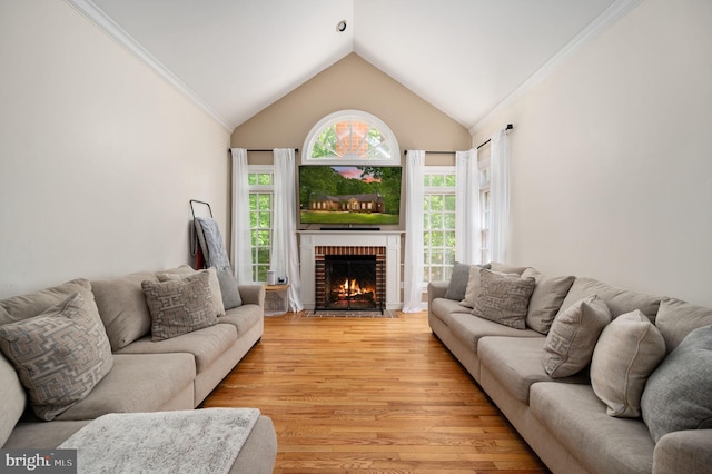living area with ornamental molding, a brick fireplace, light wood-type flooring, and lofted ceiling