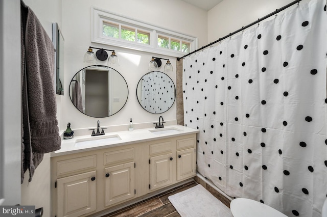 full bath featuring double vanity, a sink, wood finished floors, and curtained shower
