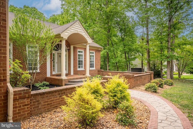 exterior space with brick siding and a shingled roof