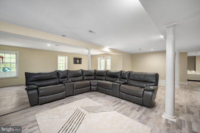 living room with ornate columns, wood finished floors, a healthy amount of sunlight, and visible vents