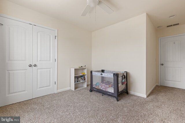 carpeted bedroom with baseboards, ceiling fan, a closet, and visible vents