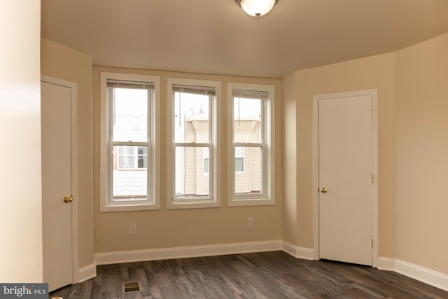 unfurnished room featuring dark wood-style floors and baseboards