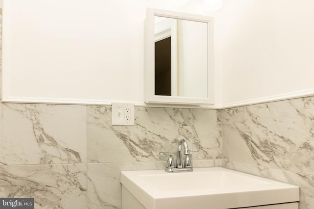 bathroom with vanity and tile walls
