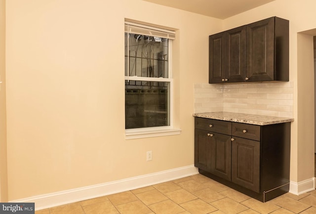 bar with baseboards, tasteful backsplash, and light tile patterned floors