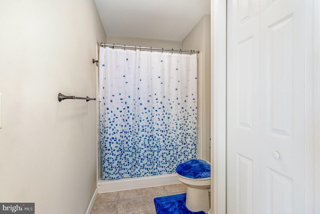 bathroom featuring baseboards, a shower stall, and toilet
