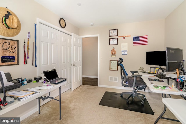 home office featuring baseboards, light carpet, and visible vents