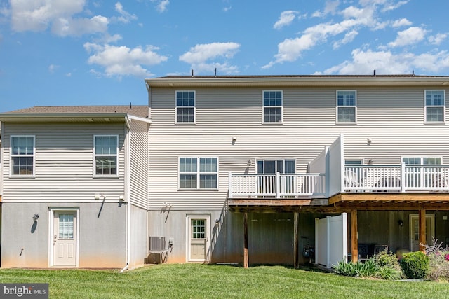 back of property featuring a lawn, a wooden deck, and central AC