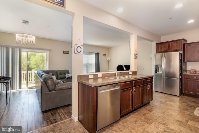 kitchen with a sink, a wealth of natural light, open floor plan, and stainless steel appliances