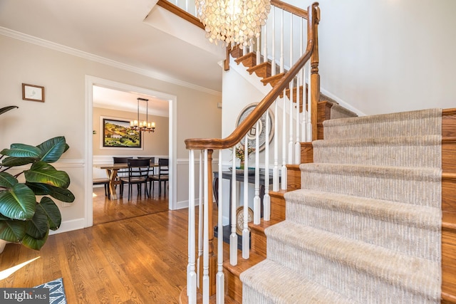 4690 Derby Ln, Doylestown, PA 18902 - stairs featuring a chandelier, crown molding, wood finished floors, and a wainscoted wall