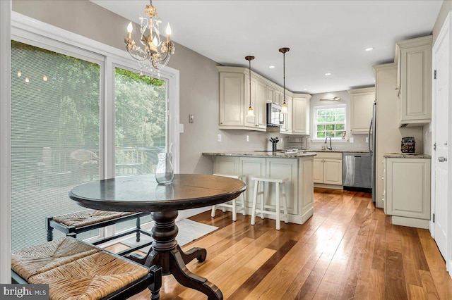 317 Nicholas, Wilmington, DE 19808 - kitchen with stainless steel appliances, a chandelier, light wood-style flooring, a peninsula, and a sink