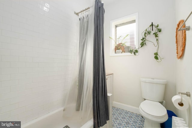 bathroom featuring baseboards, shower / bath combination with curtain, and toilet