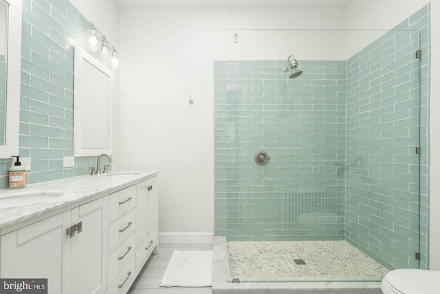 full bath featuring double vanity, a shower stall, and a sink