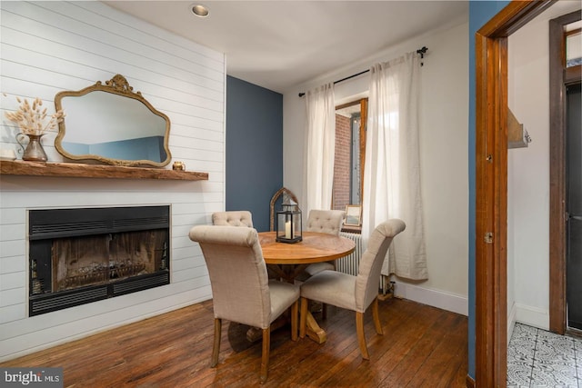 dining space with recessed lighting, baseboards, a large fireplace, and hardwood / wood-style floors