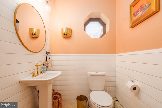 half bathroom with toilet and wainscoting
