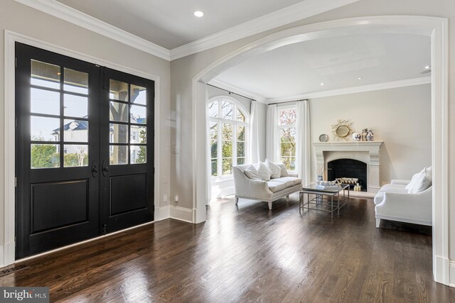 foyer entrance featuring french doors, arched walkways, crown molding, and dark wood-type flooring