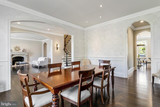 dining area featuring arched walkways, dark wood finished floors, recessed lighting, and stairway