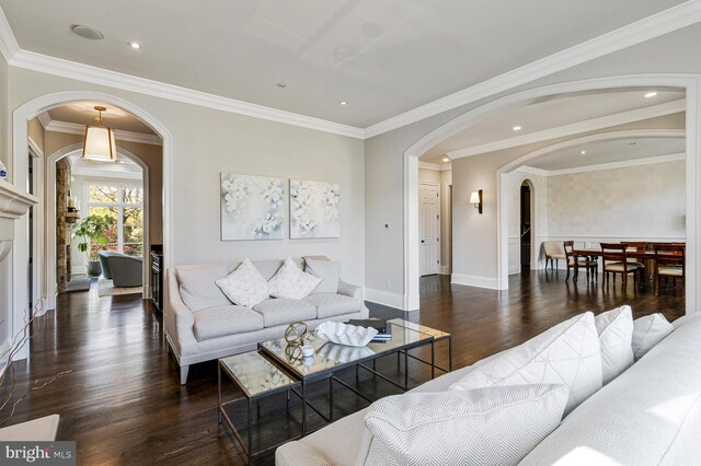 living area with crown molding, arched walkways, wood finished floors, and recessed lighting