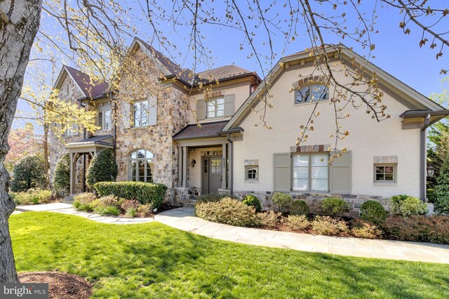 view of front of house featuring a front lawn and stone siding