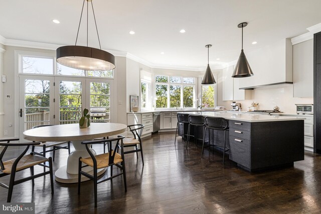 kitchen with crown molding, a kitchen island, recessed lighting, light countertops, and stainless steel appliances