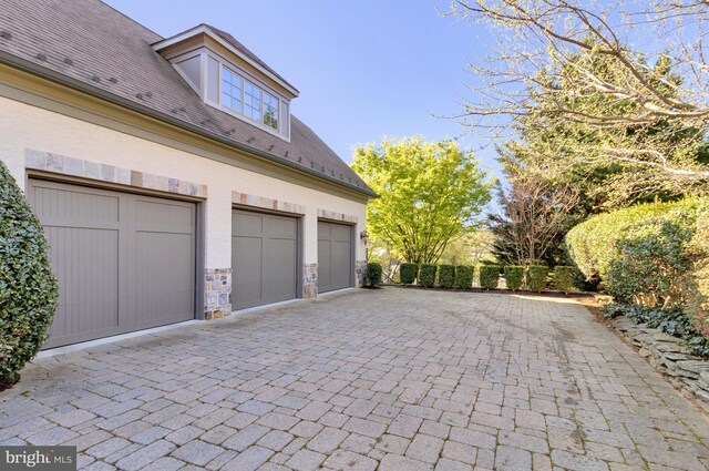 garage with decorative driveway