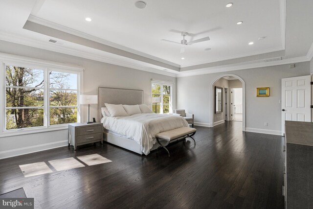 bedroom with visible vents, arched walkways, dark wood finished floors, a raised ceiling, and ornamental molding