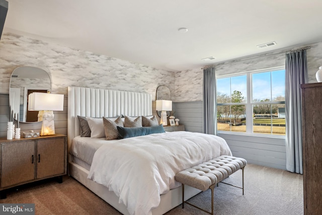 carpeted bedroom with wainscoting and visible vents