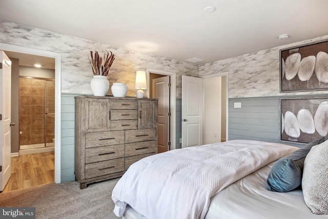 bedroom with light wood-style flooring and connected bathroom