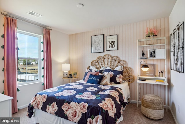 carpeted bedroom featuring visible vents, baseboards, and wallpapered walls