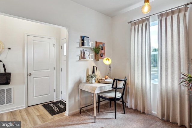 office space with visible vents, baseboards, and wood finished floors