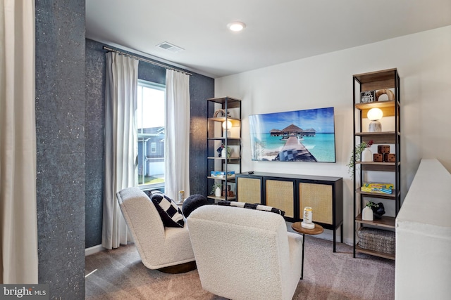 living area featuring carpet floors, baseboards, and visible vents