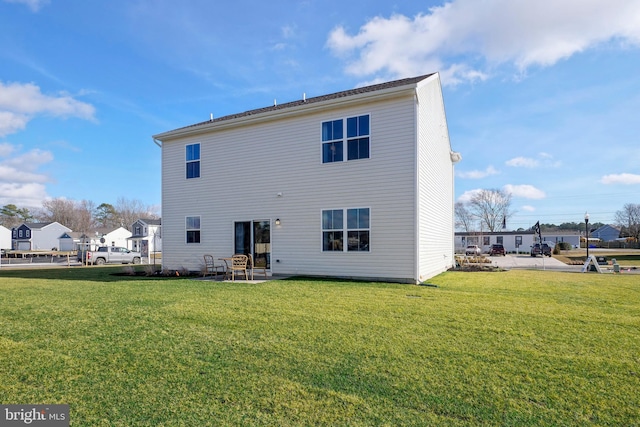 back of property with a yard and a patio