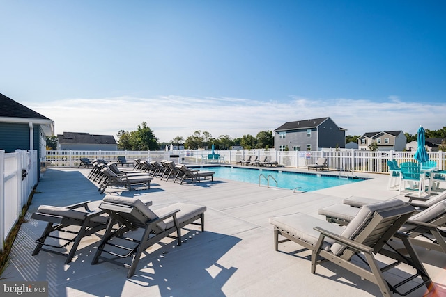 community pool with a patio and fence