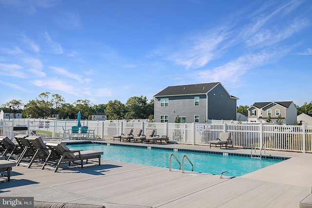 pool with a patio and fence